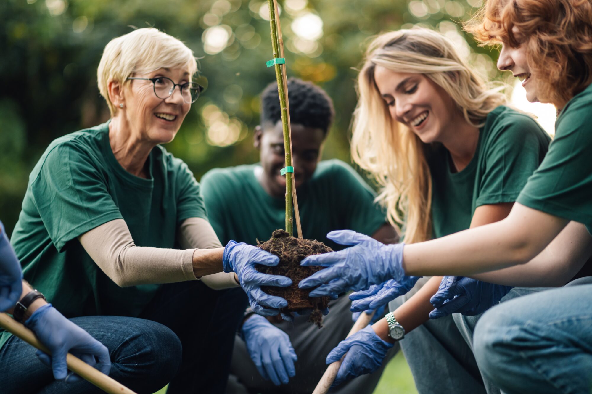 Diverse group of volunteers planting a tree